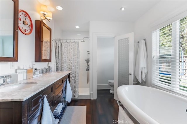 full bathroom featuring toilet, independent shower and bath, wood-type flooring, and vanity