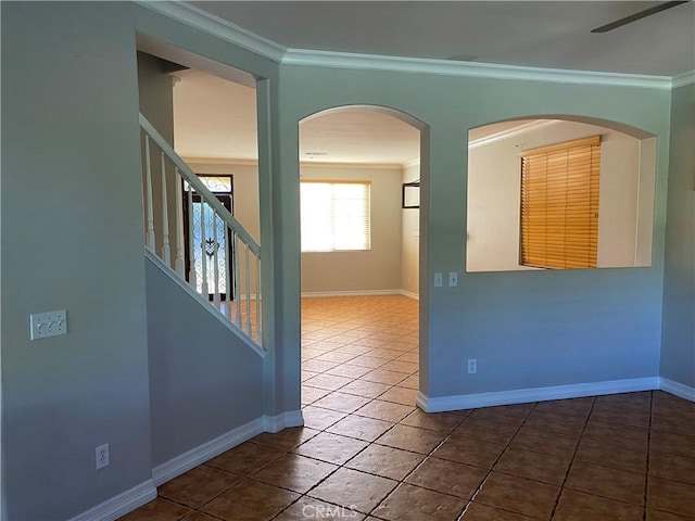 tiled spare room featuring ceiling fan and ornamental molding