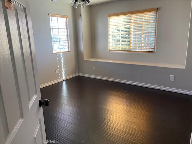 unfurnished room featuring ceiling fan and dark wood-type flooring