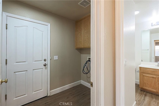 laundry room with washer hookup, cabinets, dark hardwood / wood-style flooring, and sink