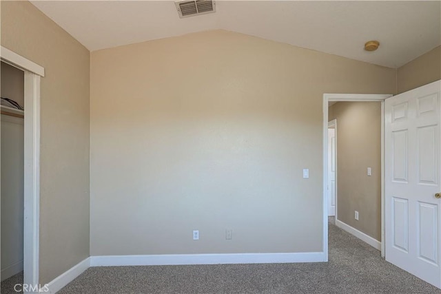 unfurnished bedroom with vaulted ceiling and carpet flooring