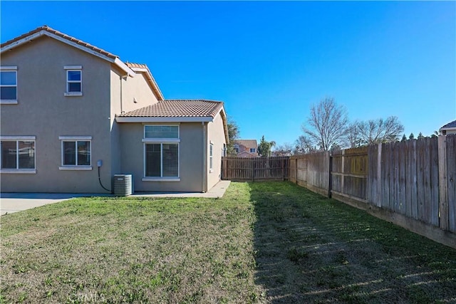 back of house featuring cooling unit, a patio, and a yard