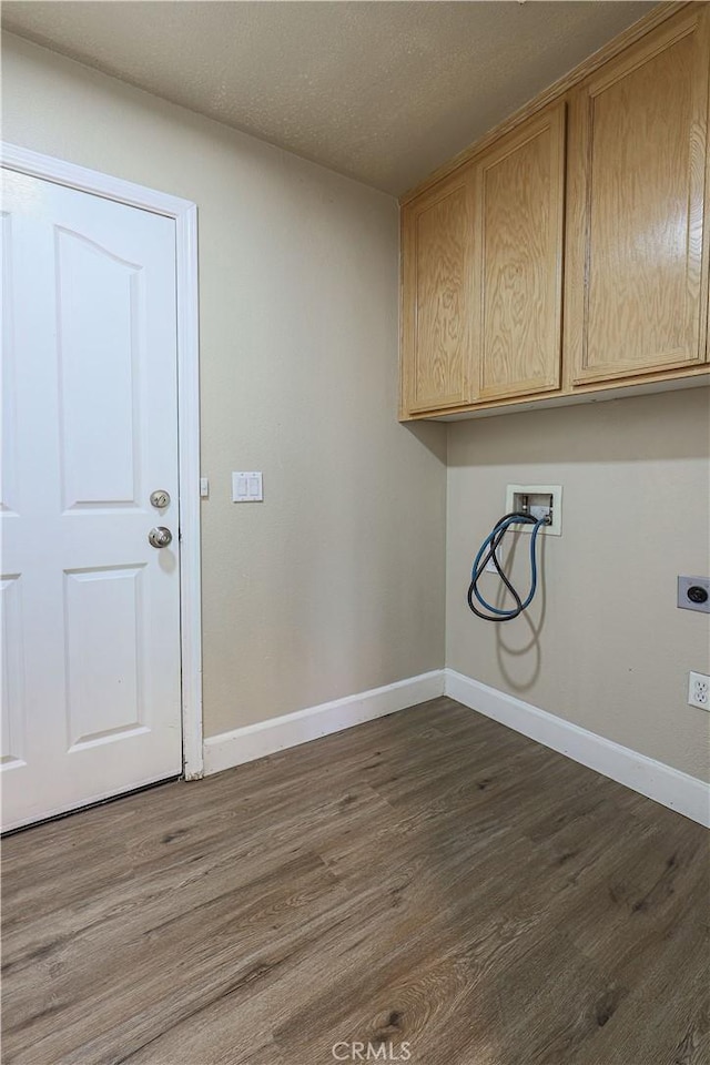 laundry area featuring hookup for a washing machine, a textured ceiling, dark hardwood / wood-style flooring, hookup for an electric dryer, and cabinets