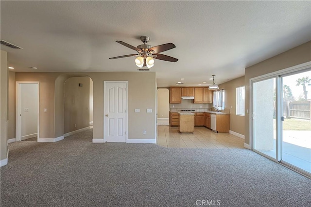 unfurnished living room featuring ceiling fan and light carpet