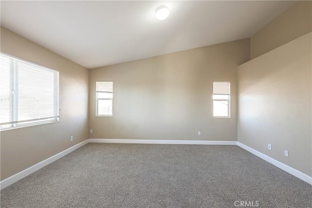 carpeted spare room with lofted ceiling