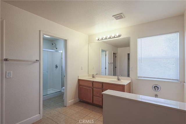 bathroom featuring a shower with shower door, vanity, tile patterned floors, and toilet