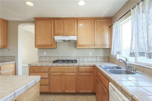 kitchen featuring stainless steel gas cooktop, light tile patterned floors, sink, and tile countertops