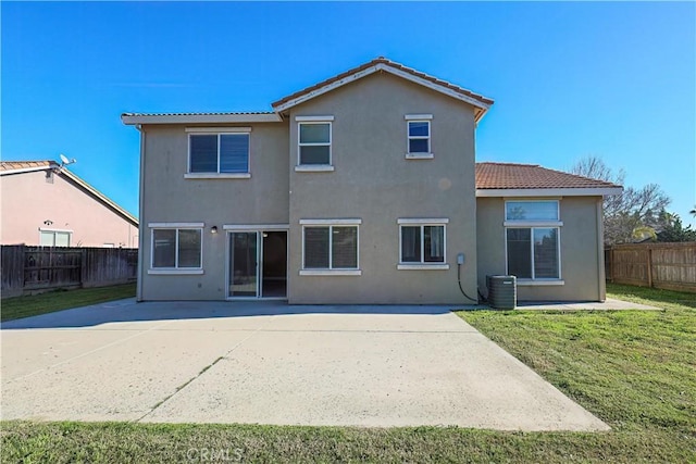 rear view of house with a lawn, central AC, and a patio