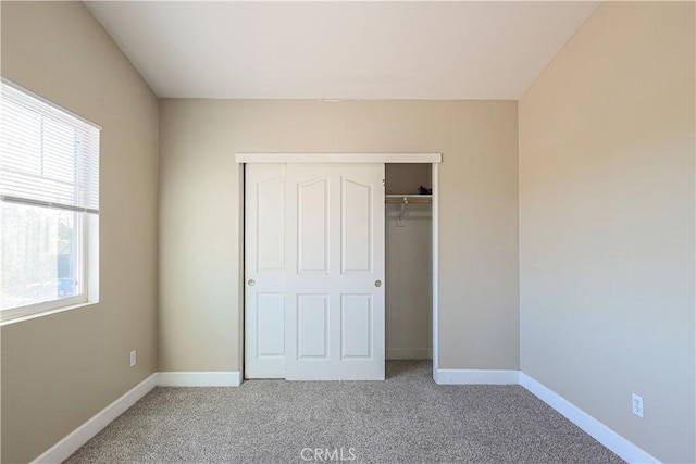 unfurnished bedroom featuring carpet floors, a closet, and multiple windows