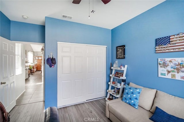 living area with ceiling fan and light hardwood / wood-style flooring