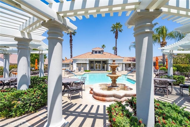 view of swimming pool featuring an outbuilding, a patio area, and a pergola