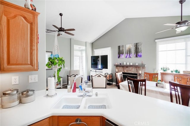 kitchen with a premium fireplace, vaulted ceiling, sink, and ceiling fan