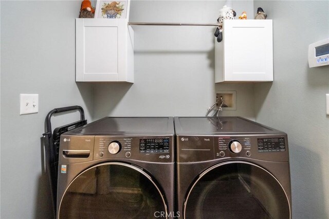 laundry area with cabinets and washing machine and clothes dryer