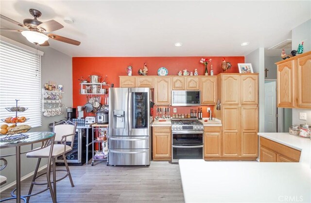 kitchen featuring light hardwood / wood-style floors, light brown cabinets, appliances with stainless steel finishes, and ceiling fan