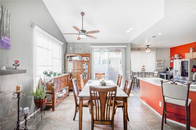 tiled dining space featuring lofted ceiling and ceiling fan