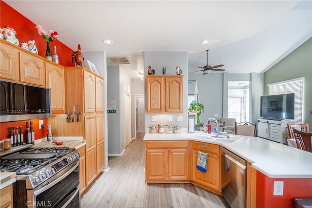 kitchen with ceiling fan, vaulted ceiling, light hardwood / wood-style floors, sink, and stainless steel appliances