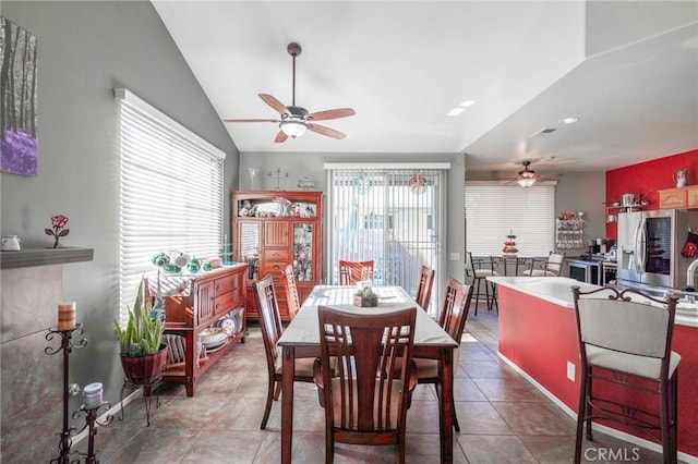 tiled dining area featuring ceiling fan, vaulted ceiling, and a wealth of natural light