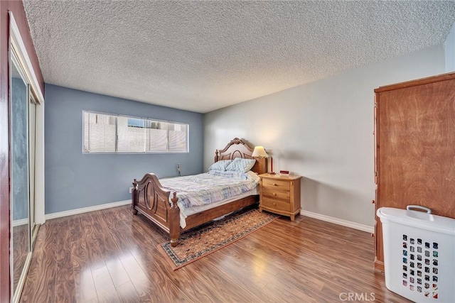 bedroom with dark hardwood / wood-style floors and a textured ceiling