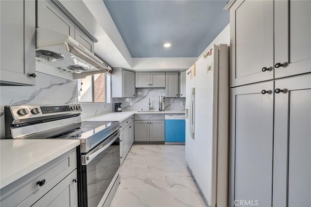 kitchen with sink, gray cabinets, appliances with stainless steel finishes, range hood, and decorative backsplash