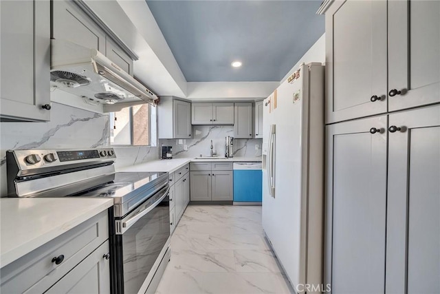 kitchen featuring white refrigerator with ice dispenser, dishwasher, marble finish floor, stainless steel electric stove, and gray cabinets