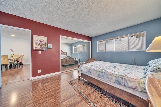 bedroom with hardwood / wood-style floors, a closet, and a textured ceiling