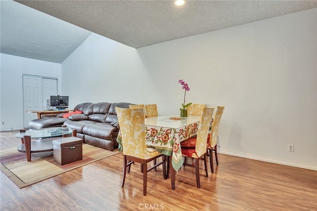 dining space featuring hardwood / wood-style floors and a textured ceiling