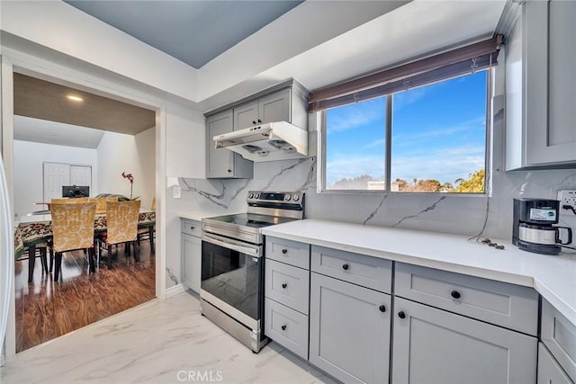 kitchen featuring stainless steel range with electric stovetop, decorative backsplash, and gray cabinets