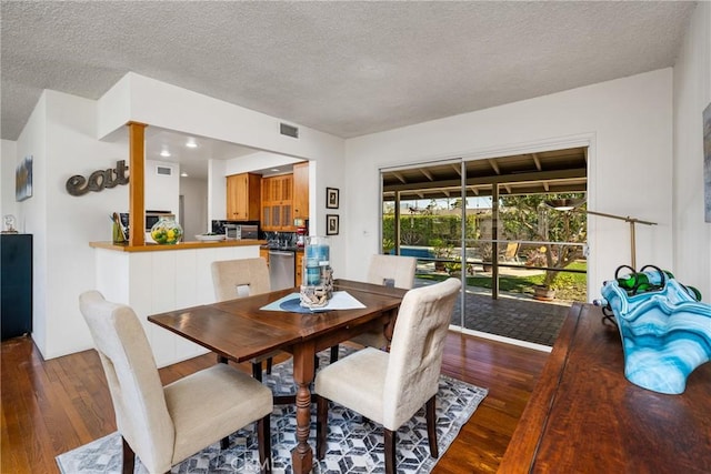 dining room featuring a textured ceiling and hardwood / wood-style floors