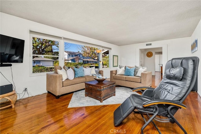 living room featuring a textured ceiling and hardwood / wood-style flooring