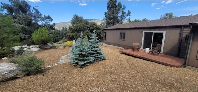 view of yard featuring a deck with mountain view