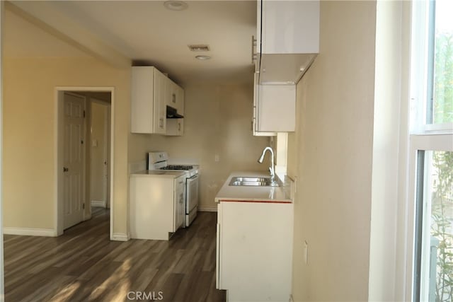 kitchen with extractor fan, dark hardwood / wood-style flooring, white cabinets, white gas range oven, and sink