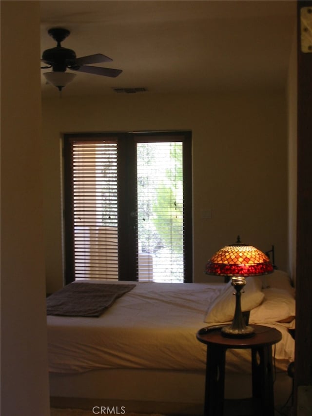 bedroom featuring ceiling fan and multiple windows