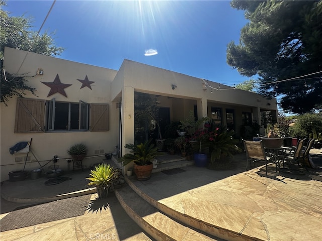 back of property with a patio