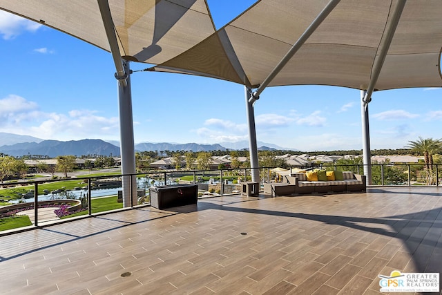 view of patio with an outdoor living space and a water and mountain view