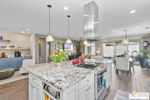 kitchen featuring white cabinets, a kitchen island, stainless steel range, island exhaust hood, and hanging light fixtures