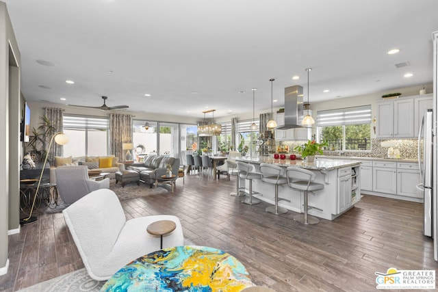 living room with ceiling fan, a healthy amount of sunlight, and dark hardwood / wood-style floors