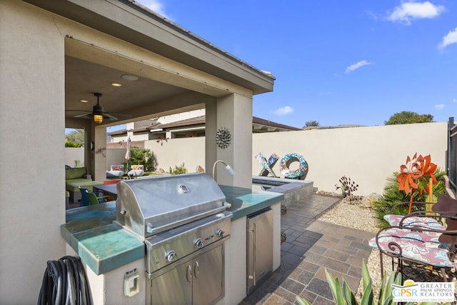 view of patio / terrace featuring ceiling fan, an outdoor kitchen, and grilling area