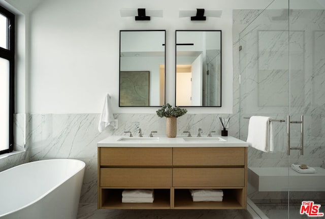 bathroom with separate shower and tub, vanity, and tile walls