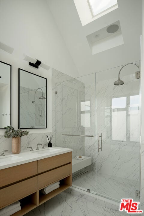 bathroom with a skylight, walk in shower, and vanity