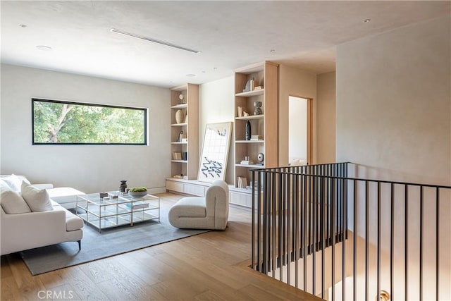 sitting room featuring built in features and light hardwood / wood-style flooring