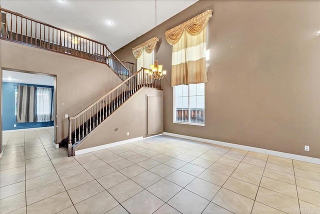 interior space featuring tile patterned floors, a high ceiling, and an inviting chandelier