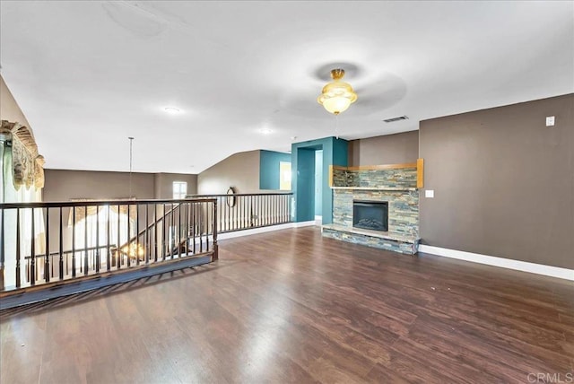 unfurnished living room with a stone fireplace, ceiling fan, lofted ceiling, and hardwood / wood-style flooring