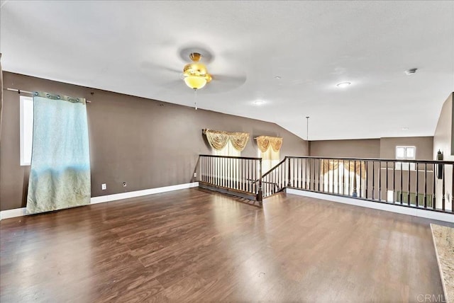 unfurnished room with lofted ceiling, ceiling fan, and dark wood-type flooring