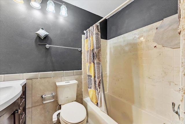 full bathroom featuring shower / bathtub combination with curtain, vanity, tile walls, and toilet