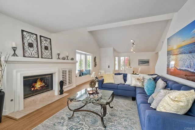 living room featuring hardwood / wood-style floors, vaulted ceiling with beams, and a high end fireplace