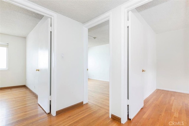 corridor featuring a textured ceiling and light wood-type flooring