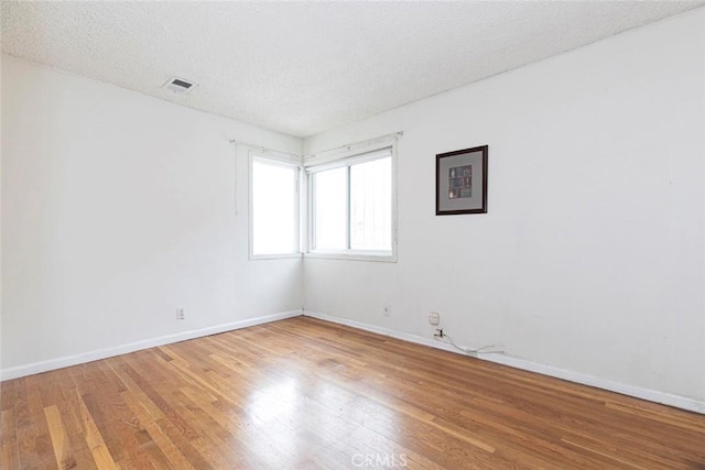 unfurnished room featuring a textured ceiling and wood-type flooring