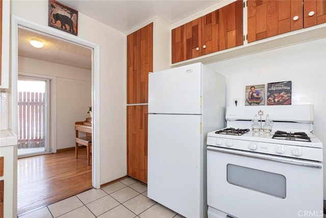 kitchen with white appliances and light tile patterned flooring