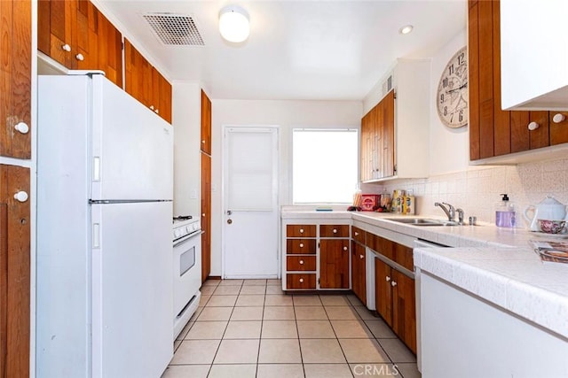 kitchen featuring light tile patterned floors, sink, tasteful backsplash, and white appliances