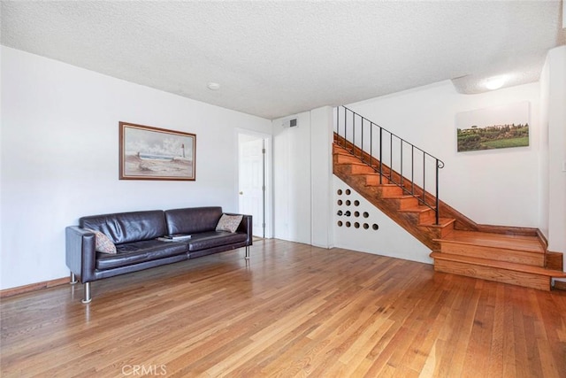 living room featuring a textured ceiling and hardwood / wood-style floors